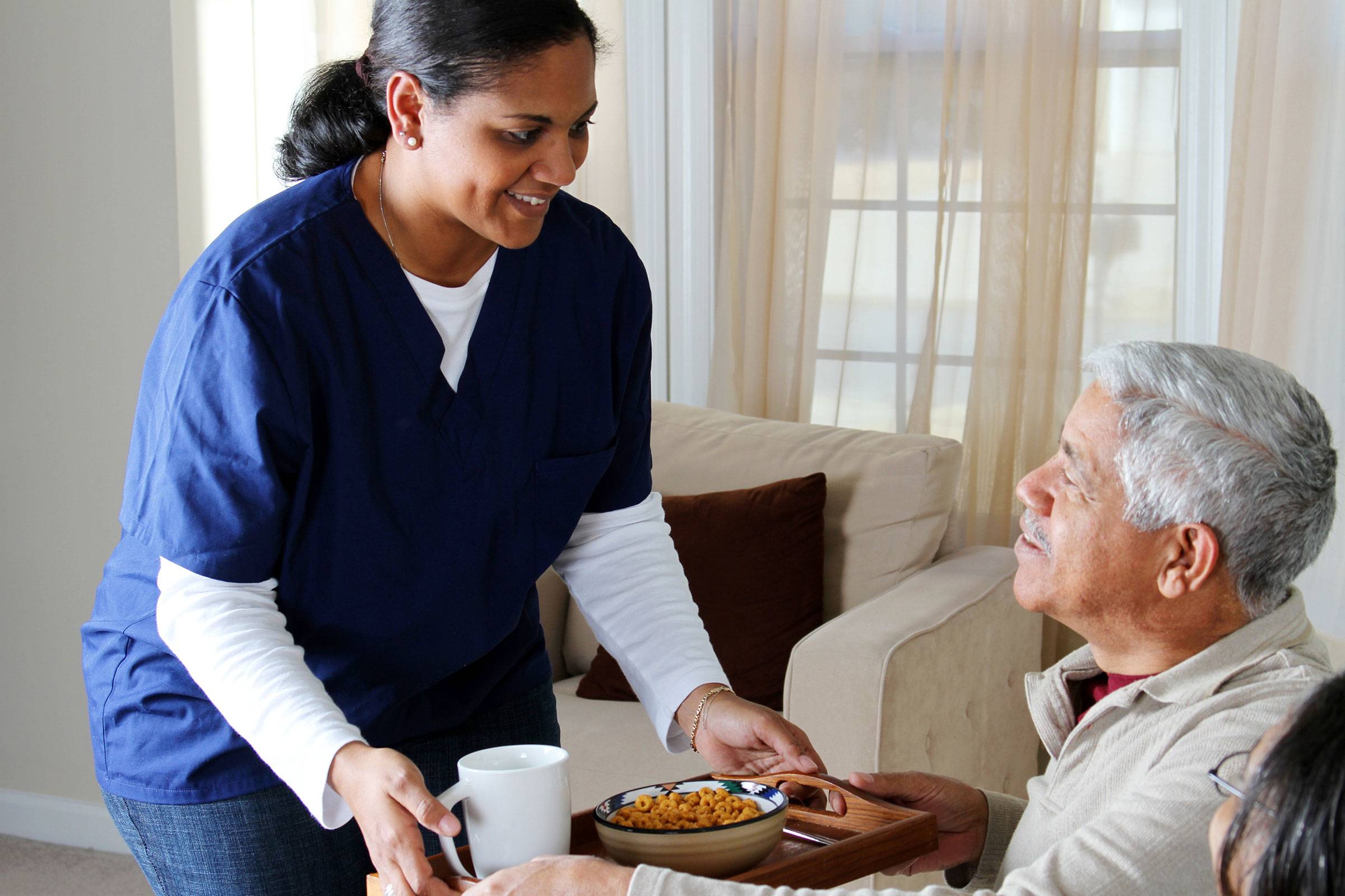 Healthcare professional helping elderly couple
